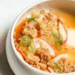 a bowl of soup with meat and vegetables.
