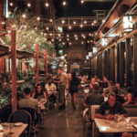 a group of people sitting at tables in a restaurant.