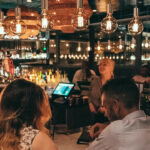 a group of people sitting around a bar.