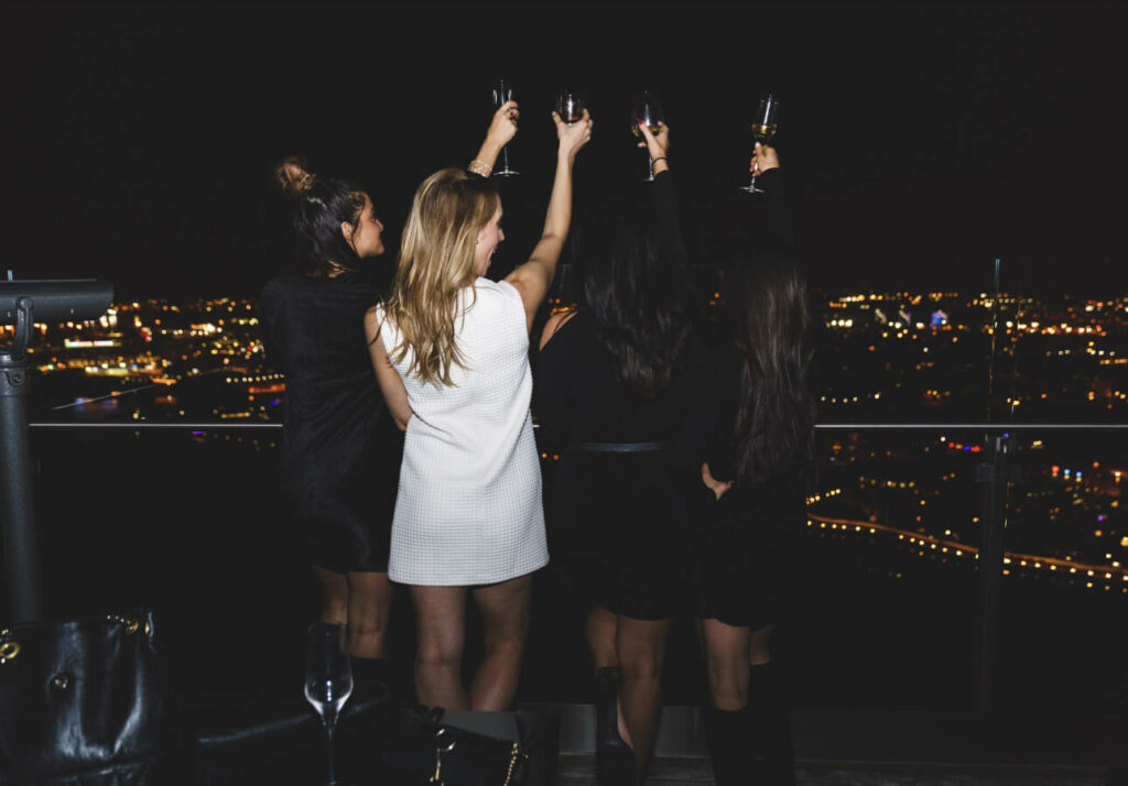 a group of women standing on top of a building.