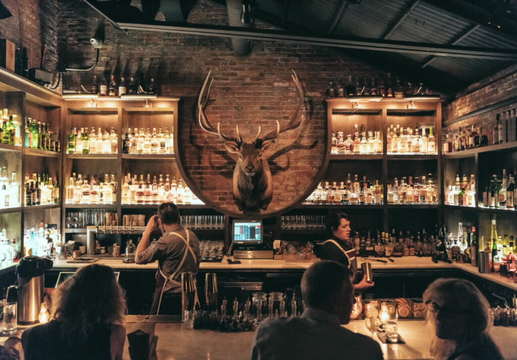 a group of people sitting around a bar.
