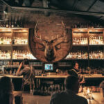 a group of people sitting around a bar.