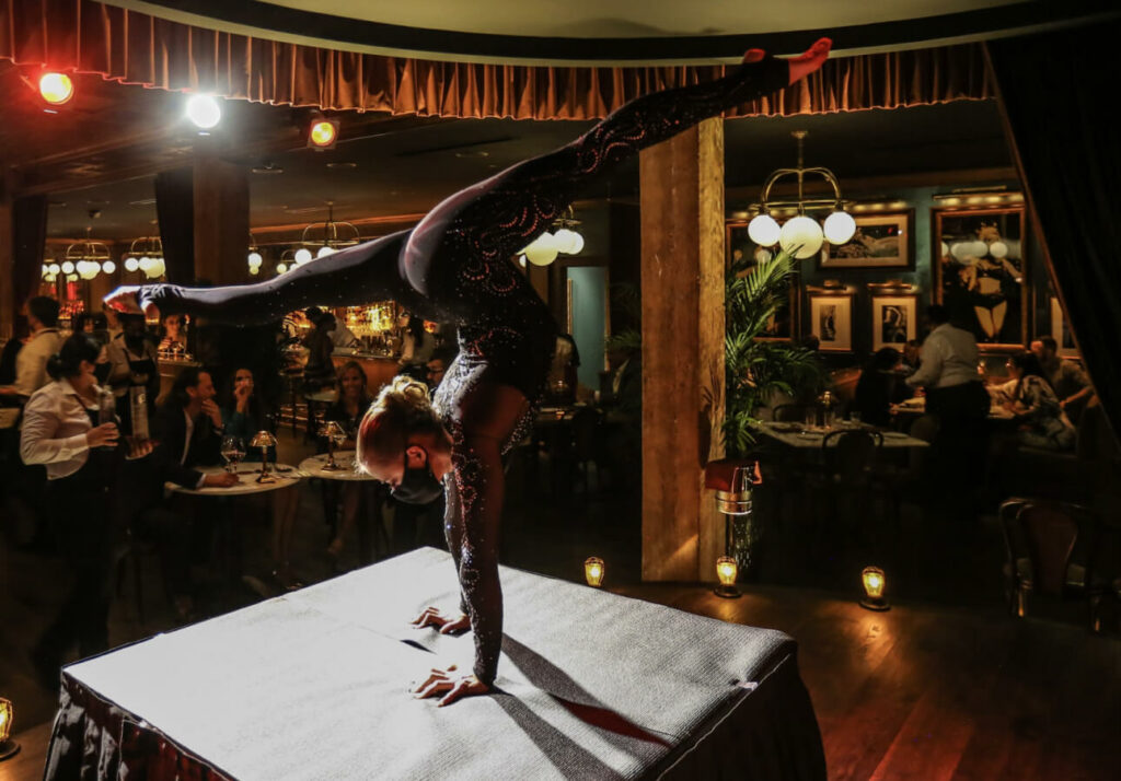 a woman doing a handstand on top of a table.