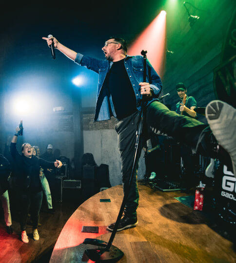 a man standing on top of a stage holding a microphone.