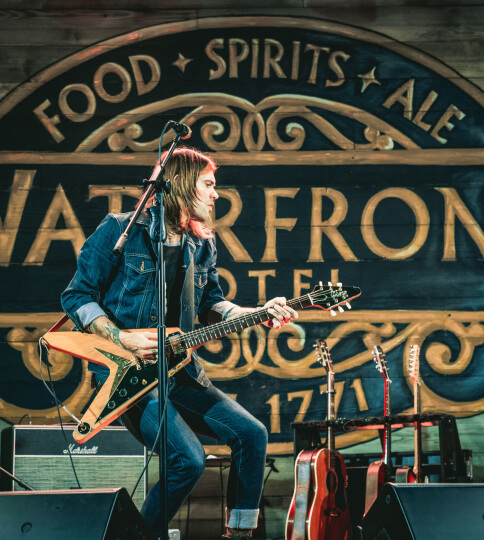 a man playing a guitar on a stage.