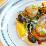 a white plate topped with food next to a menu.