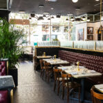 The interior of a restaurant with tables and chairs.
