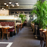 The interior of a restaurant with tables and chairs.