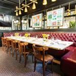 A dining room with a long table and chairs.