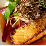 a plate with salmon and vegetables on it.