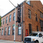 A white truck is parked in front of a brick building.